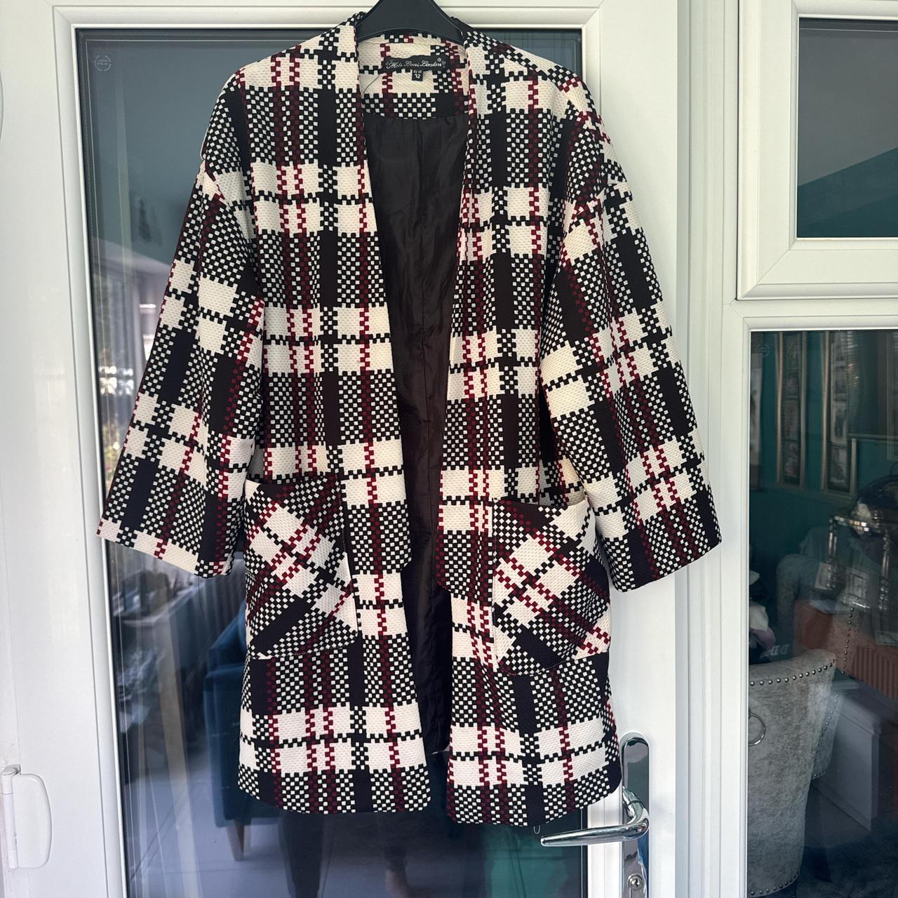 ongline check edge to edge jacket in black, red and white. Patch pockets to the front.