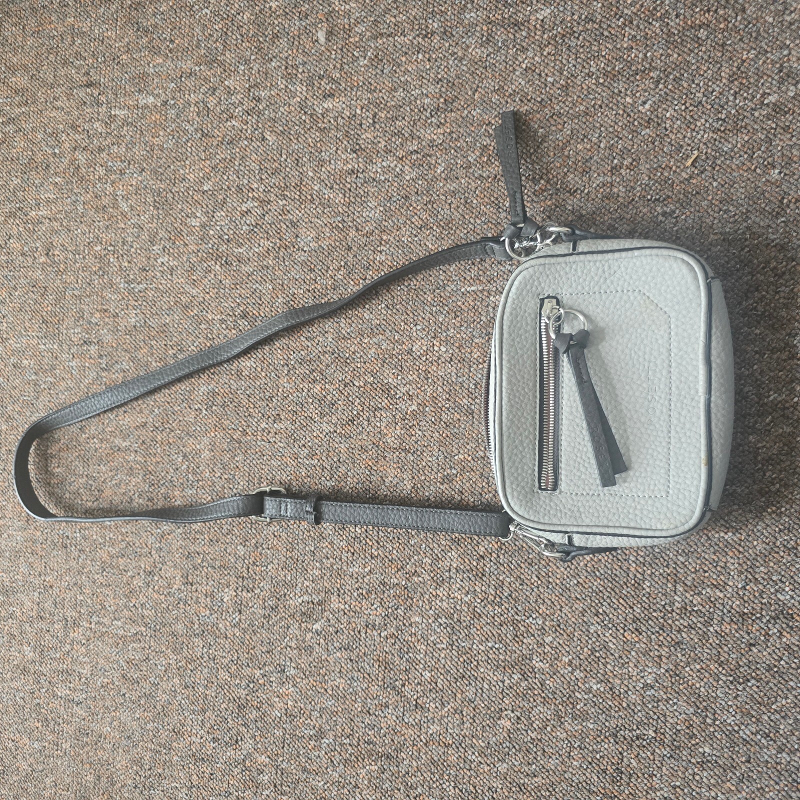 Grey pebbled faux leather crossbody bag with black strap and pink lining