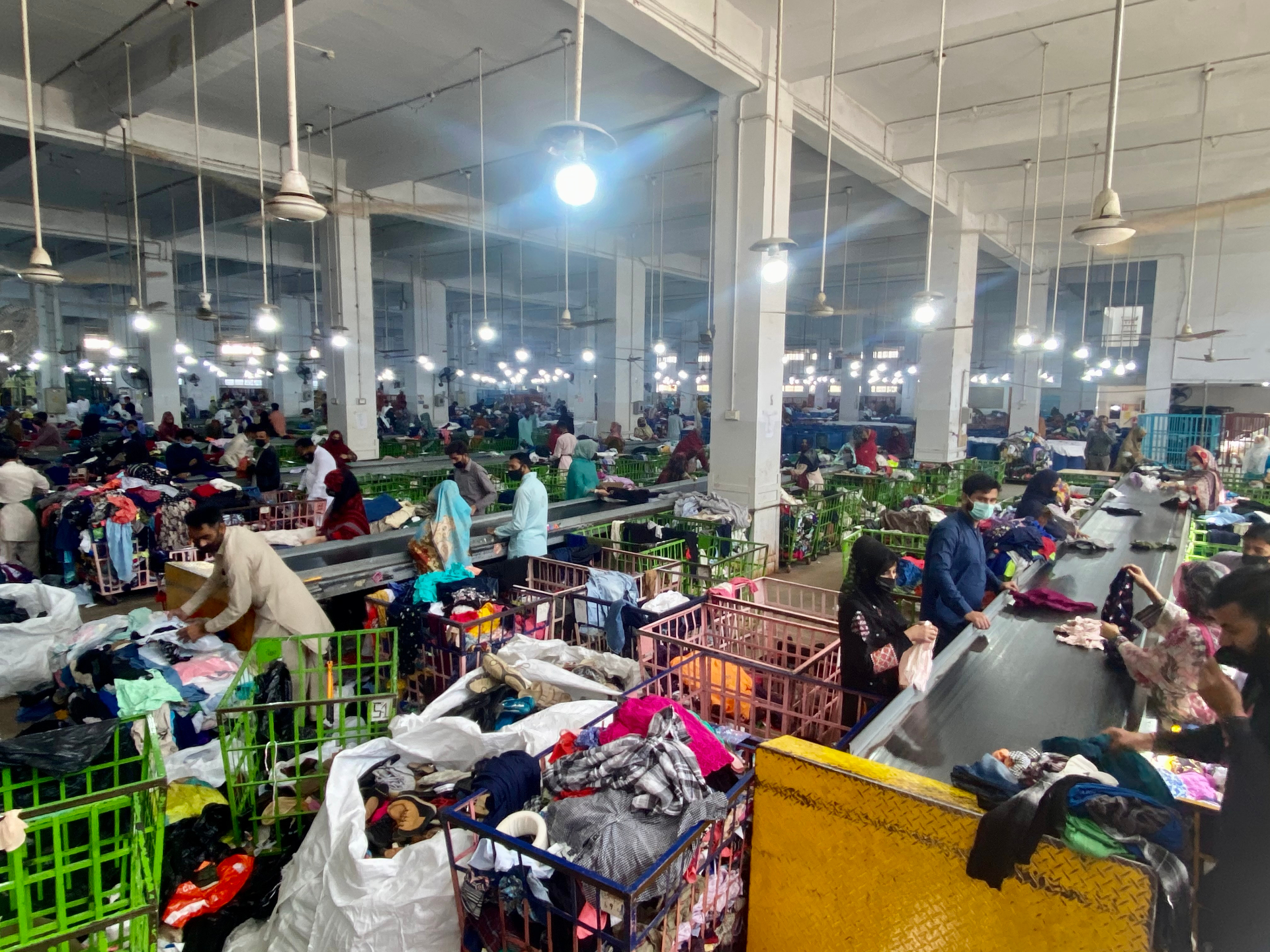 Grading floor with workers sorting clothing into blue barrels - Wholesale budget from Retex Global Pvt. Ltd., Pakistan